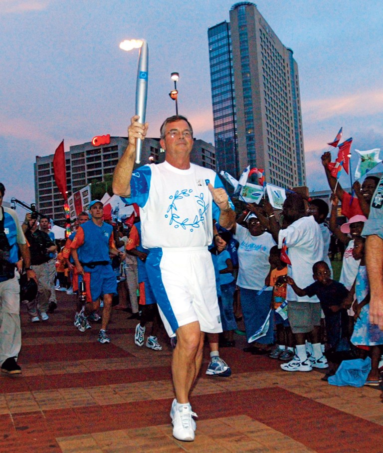 Torchbearer Billy Payne carries the Olympic Flame during Day 14 of the Athens 2004 Olympic Torch Relay 